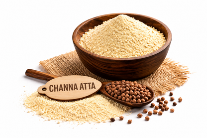 A wooden bowl filled with light beige channa atta flour, with a spoonful of brown channa beans, scattered beans, and a wooden sign reading 'CHANNA ATTA' on a white background.