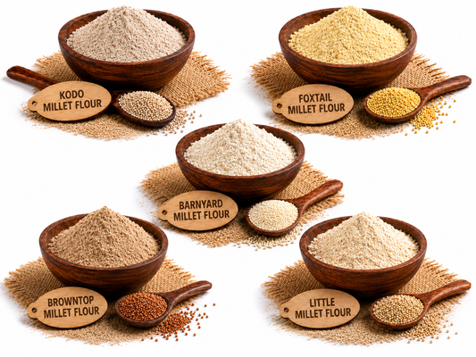 Five bowls of different millets and flours arranged on a white background, each labeled with a wooden tag reading Kodo Millet Flour, Foxtail Millet Flour, Barnyard Millet Flour, Browntop Millet Flour, and Little Millet Flour.